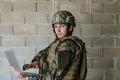 American soldier in military uniform using laptop computer for drone controlling and to stay in contact with friends and Royalty Free Stock Photo