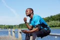 American sports man sitting outside listening to music