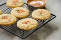 American style round cookies with confetti (shortbread) on a wire rack on a grey stone backdrop.