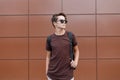 American stylish hipster young man in a stylish T-shirt in black sunglasses with a fashionable hairstyle with Royalty Free Stock Photo