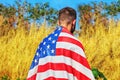 American teenager is stands on an American field with the flag USA on the back. Concepts: patriotic holiday - Independence Day Royalty Free Stock Photo