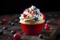 American vanilla sweet cupcake in color USA flag on dark background. Food for Patriotic Independence Day 4th of july.