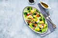 American version of Nicoise salad with canned tuna, boiled potatoes and green asparagus beans in an oval white dish on a gray Royalty Free Stock Photo