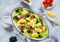 American version of Nicoise salad with canned tuna, boiled potatoes and green asparagus beans in an oval white dish on a gray Royalty Free Stock Photo
