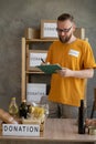American volunteer going through donation checklist while working at food bank. charity, donation and volunteering Royalty Free Stock Photo