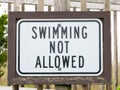 An american warning sign at the beach with man swim and not symbol, Caution No Swimming allowed Royalty Free Stock Photo