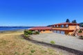 American waterfront house, orange exterior paint and three garage spaces