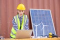 American women engineer and caucasian electrician wearing yellow hard hat working on laptop computer