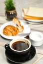 Americano coffee served in cup with croissant, puff pastry, bread and knife isolated on napkin side view cafe breakfast Royalty Free Stock Photo