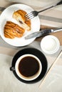 Americano coffee served in cup with croissant, puff pastry, bread and knife isolated on napkin top view cafe breakfast Royalty Free Stock Photo