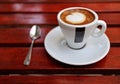 americano cup on saucer with spoon, ashtray, glass of water on red wooden coffee shop table (espresso, milk cappuccino) Royalty Free Stock Photo