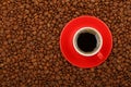 Americano in red cup with saucer on coffee beans Royalty Free Stock Photo