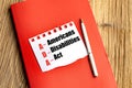 Americans with Disabilities Act text on torn paper placed on red notebook with pen on wooden background Royalty Free Stock Photo