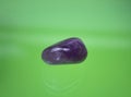 An amethyst as tumbled gemstone and healing stone