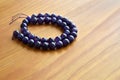Amethyst bead strand on wood with copy space.