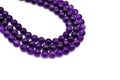 Amethyst bead strands on white background. Purple or violet crystal stone. Royalty Free Stock Photo