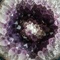 Amethyst geode with a circular arrangement of sharp, translucent crystals in varying Royalty Free Stock Photo