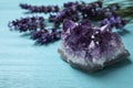 Amethyst and healing herbs on blue wooden table, closeup