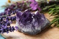 Amethyst and healing herbs on wooden board