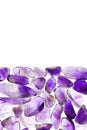 Amethyst heap stones texture on half white light isolated background. Place for text