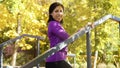 Amiable female model posing on sports ground in autumn