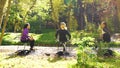 Amiable girls in sportswear sitting in sunshine in public park