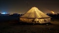 Amidst the chaotic energy and vibrant chaos of Burning Man a tent glows with a peaceful aura. The distant blur of the Royalty Free Stock Photo