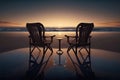 Two chairs on the beach at sunset with reflection in water