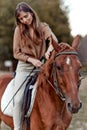 Amidst rural landscapes, a woman bonds with her horse on a grassy field. A portrait of a young jockey highlights farm training and Royalty Free Stock Photo