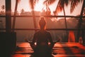 Person meditating on a balcony during a tropical sunrise