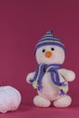 Soft DIY toy made of natural cotton and wool. Crocheted, handmade art. Amigurumi one small white snowman with orange Royalty Free Stock Photo