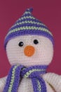 Soft DIY toy made of natural cotton and wool. Crocheted, handmade art. Amigurumi one small white snowman with orange Royalty Free Stock Photo
