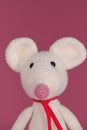 Amigurumi one white mouse with big ears and long nose on a pink background. A soft DIY toy made of natural cotton and Royalty Free Stock Photo