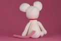 Amigurumi one white mouse with big ears and long nose on a pink background. A soft DIY toy made of natural cotton and Royalty Free Stock Photo