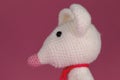 Amigurumi one white mouse with big ears and long nose on a pink background. A soft DIY toy made of natural cotton and Royalty Free Stock Photo