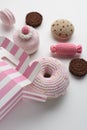 Amigurumi toy sweets. Knitted pink and chocolate donut, macarons, candy and cookies on white background