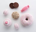 Amigurumi toys. Knitted pink and chocolate play donut, macarons, candy and cookies on white background