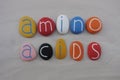 Amino acids word composed with colored stones over white sand Royalty Free Stock Photo