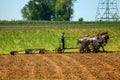 Amish Boy Plowing the Field with 5 Horses Pulling Plow to Turn Over Fields to get Ready for Planting