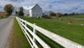 A traditional Amish barn and a white picket fence in the middle of Ohio, USA Royalty Free Stock Photo