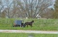 Amish Horse and Buggy Traveling Along a Countryside Road Thru Farmlands Royalty Free Stock Photo