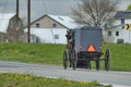 Amish Horse and Buggy Traveling Along a Countryside Road Thru Farmlands Royalty Free Stock Photo