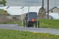 Amish Horse and Buggy Traveling Along a Countryside Road Thru Farmlands Royalty Free Stock Photo