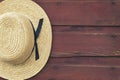 Amish man's straw hat hangs on a red barn door