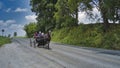 Amish Open Horse and Buggy Approaching With a Couple and Daughter in it Royalty Free Stock Photo