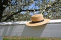 Amish straw hat on a white fence