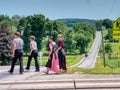 Amish Teenagers Walking Along Train Tracks in Countryside on a Sunny Day