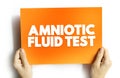 Amniotic Fluid Test is a medical procedure used primarily in the prenatal diagnosis of genetic conditions, text concept on card Royalty Free Stock Photo