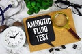 Amniotic Fluid Test text with alarm clock, calculator and stethoscope on marble background Royalty Free Stock Photo