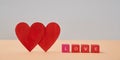 Amour and fondness. Saint Valentines Day. Love and relationship. Two red hearts, wooden cubes with love inscription